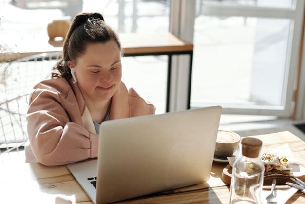 Disabilities in Israel - young woman with down syndrome using laptop